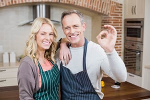 cute-couple-doing-positive-gesture-with-fingers-kitchen